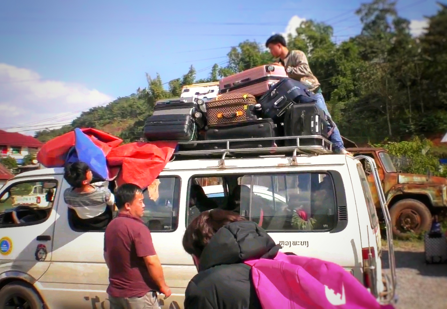 ラオスの国境を越えるトランクを山ほど積んだバス,Buses with piles of trunks crossing the border of Laos