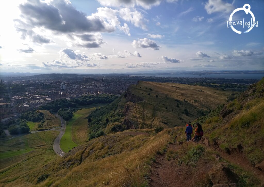 スコットランド：エジンバラ：裏山の黄金色の丘を降りる人々